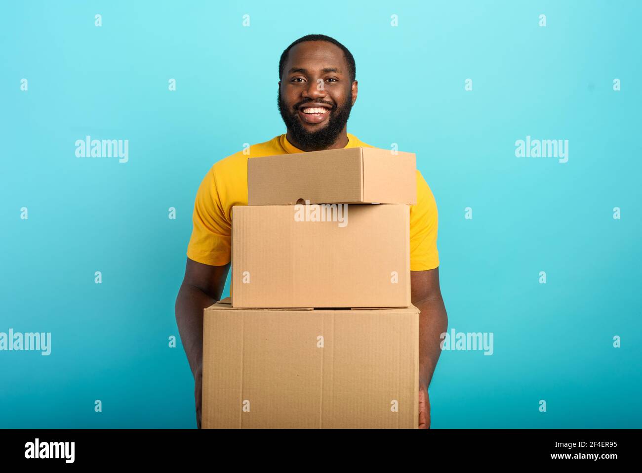 Happy boy receives a package from online shop order. Blue background. Stock Photo