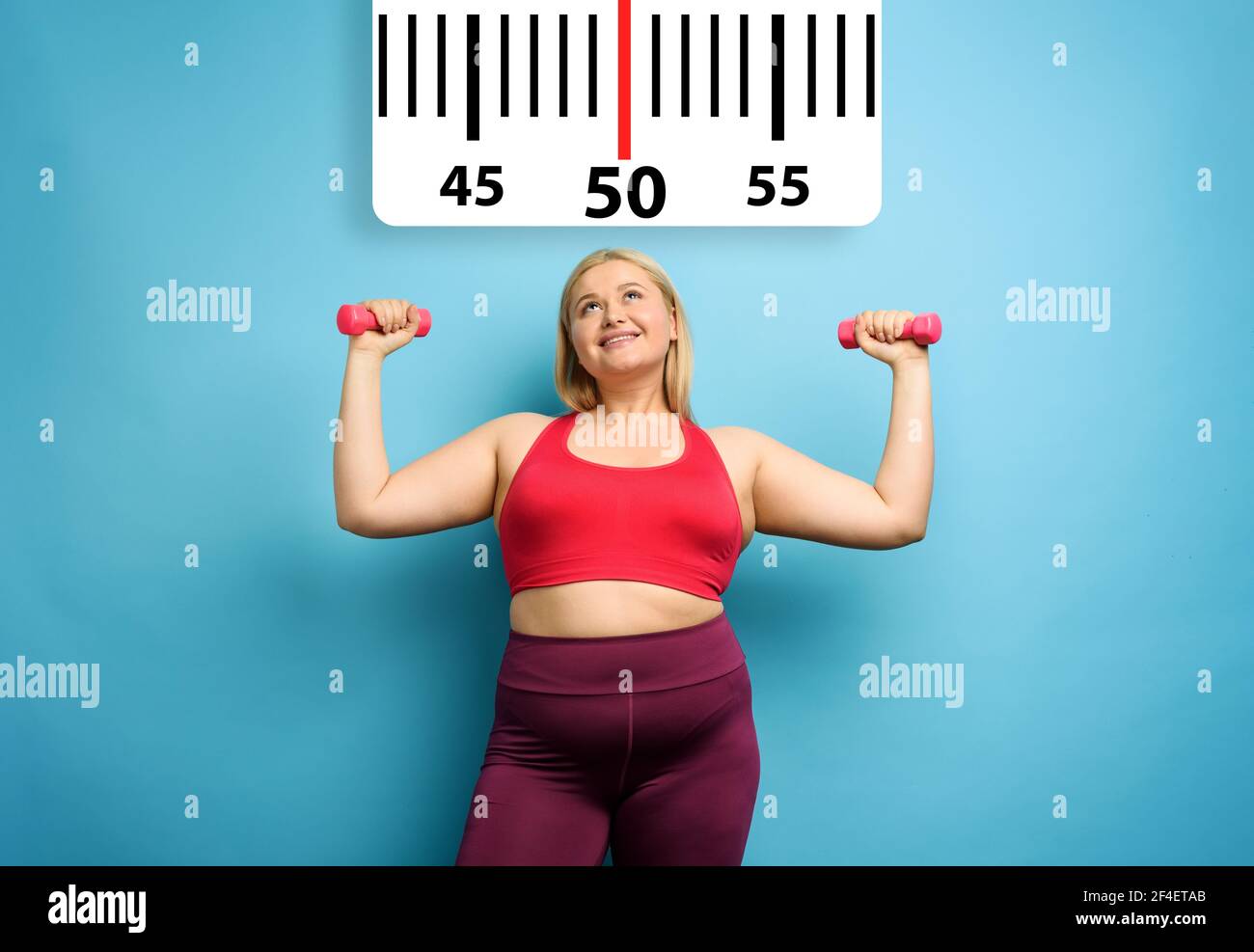 Fat girl does gym at home with satisfied expression because she decrease her weight. Cyan background Stock Photo