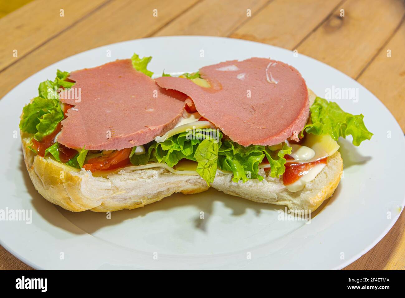 bologna sandwich with lettuce, bread, mayonnaise and ketchup. Natural