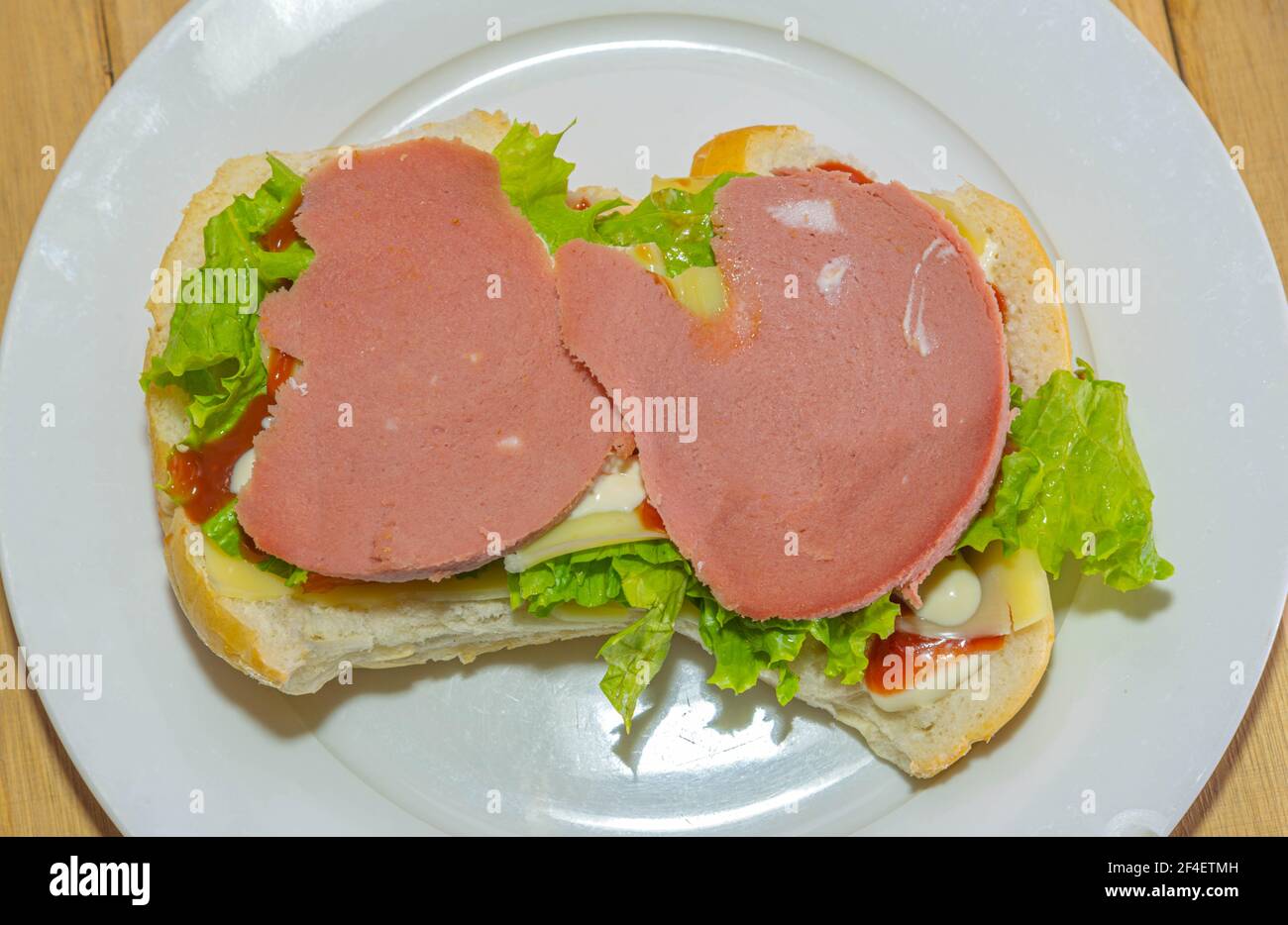 bologna sandwich with lettuce, bread, mayonnaise and ketchup. Natural and alternative food. The