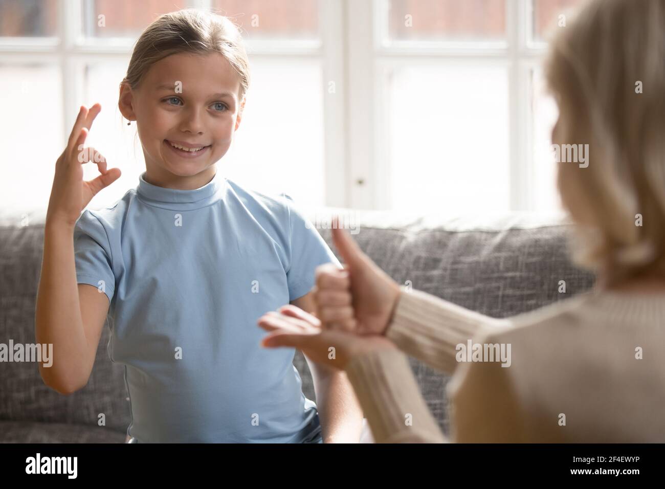 Smiling girl child talk using sign language with teacher Stock Photo