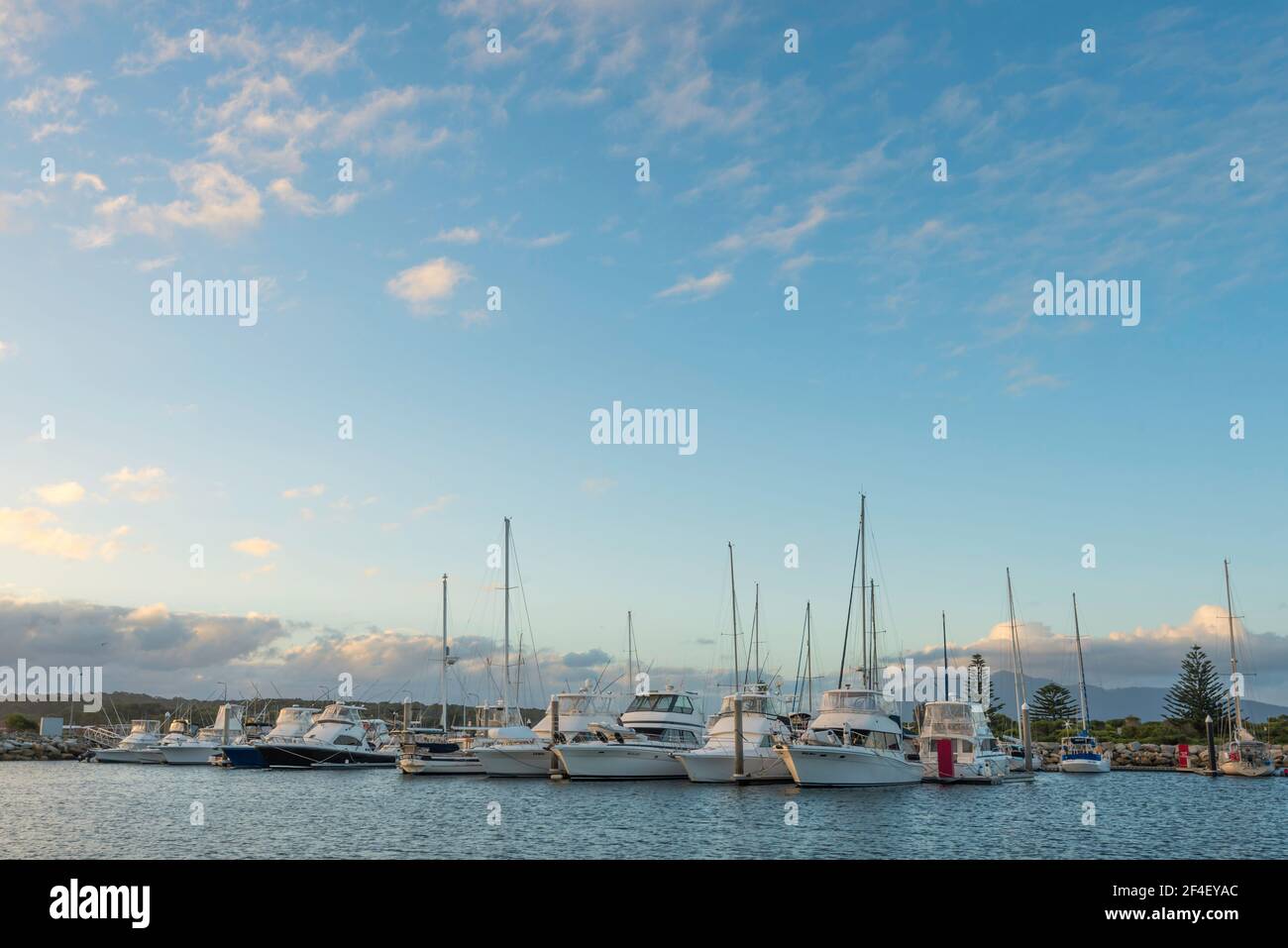 Deep sea fishing boats moored at the marina beside Bermagui Fisherman's Wharf in the late afternoon on the New South Wales south coast in Australia Stock Photo