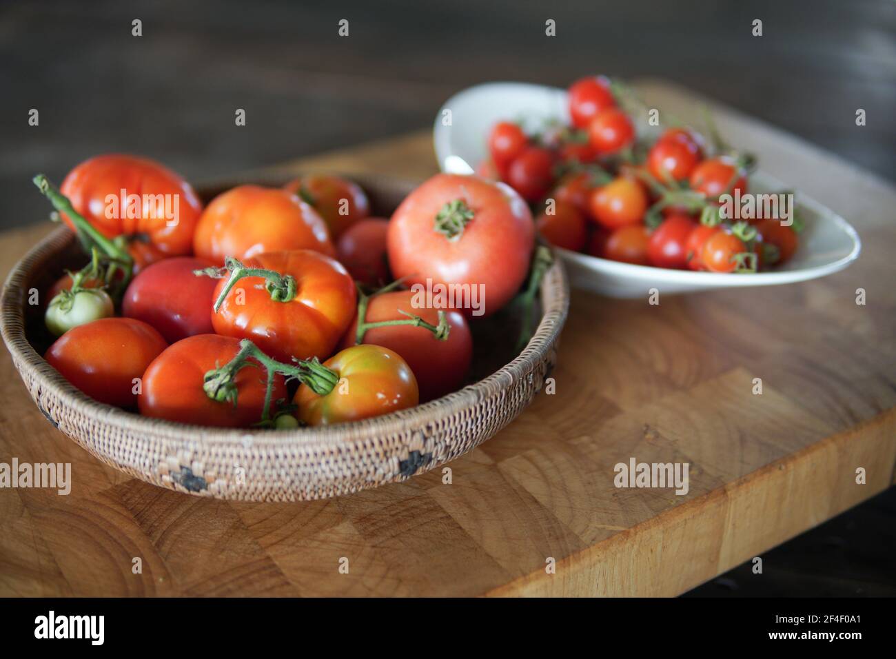fresh raw red tomatoes in basket on wooden table Stock Photo - Alamy