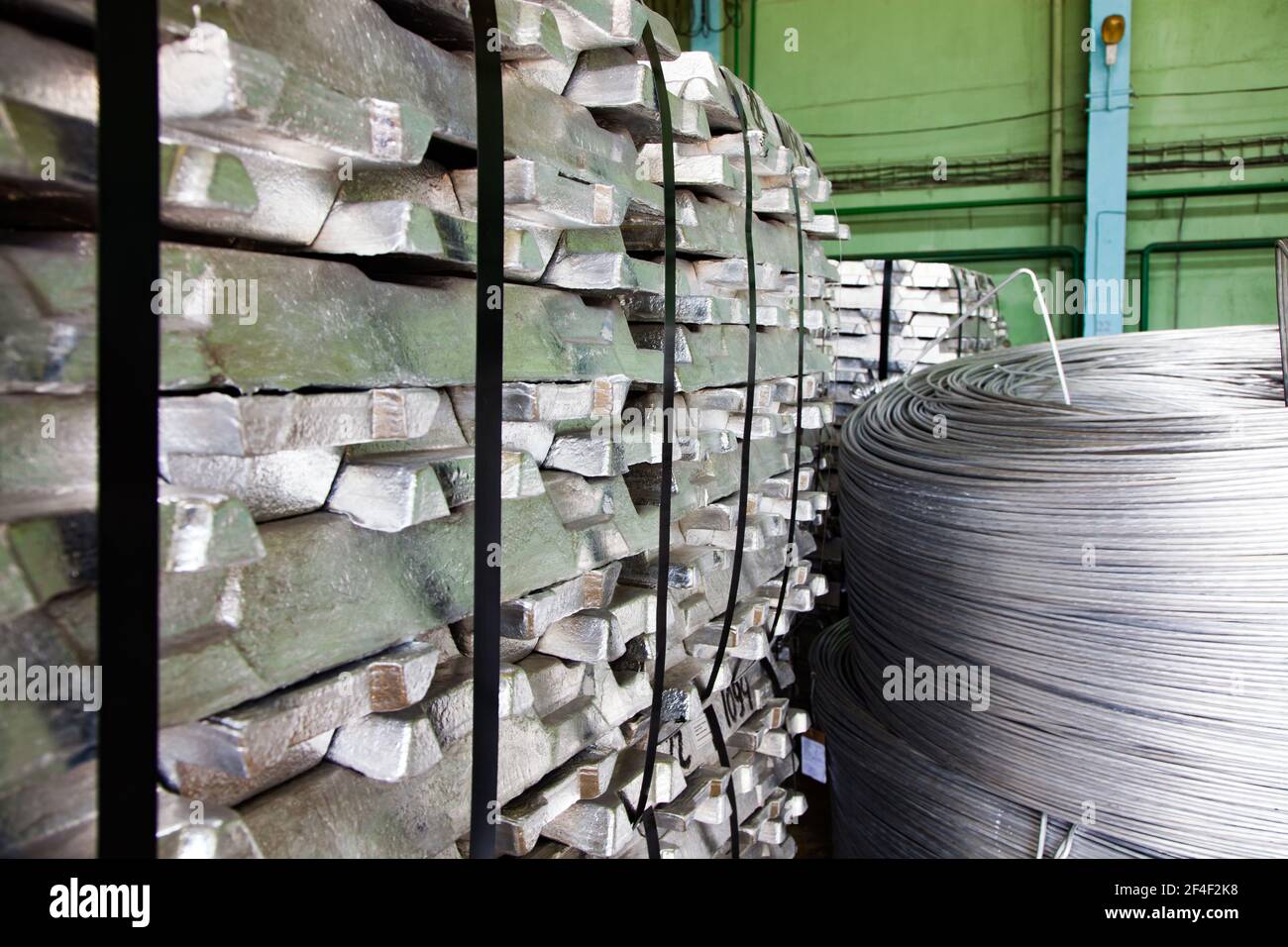 Aluminium ingots and cable rolls on factory warehouse. Stock Photo