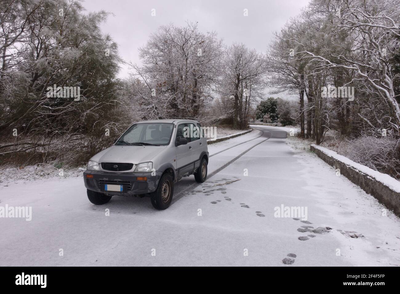 winter view in Sicily with old car Daihatsu 4x4 on a road snow covered of Etna Park Stock Photo
