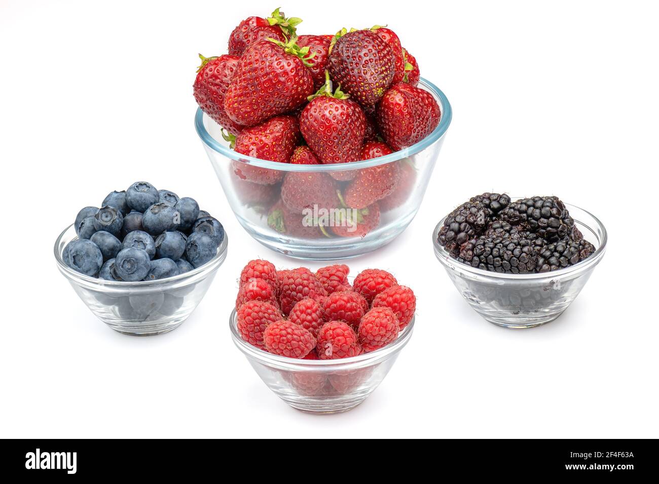 Fresh berries strawberries, raspberries, blackberries and blueberries in glass bowls isolated on white background. Berries in bowl. Stock Photo