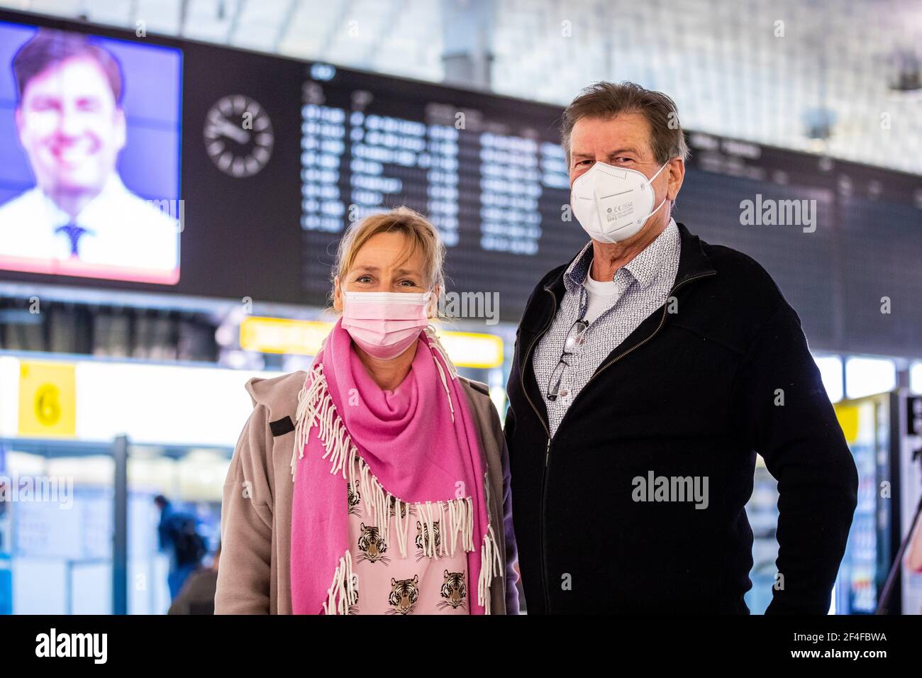 21 March 2021, Lower Saxony, Langenhagen: Natascha Schiller-Blindo and her partner Rüdiger Asche, passengers with the destination Mallorca, stand in the airport Hannover-Langenhagen. From Hanover, the largest travel group Tui flies from Sunday after a long forced break again the first holidaymakers to Mallorca. The expiration of the travel warning for the Balearic Islands makes this possible. (to dpa "Bad conscience doesn't fly with you - holidaymakers take off for Mallorca") Photo: Moritz Frankenberg/dpa Stock Photo