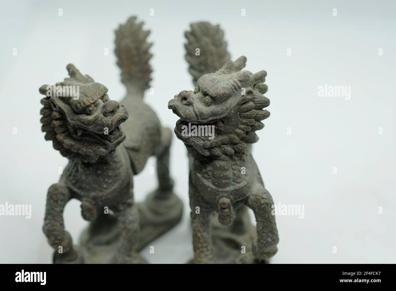 A pair of mythical Chinese bronze Qilin figurines, with head of a dragon, antlers of a deer, skin and scales of a fish, hooves of an ox & lion's tail Stock Photo