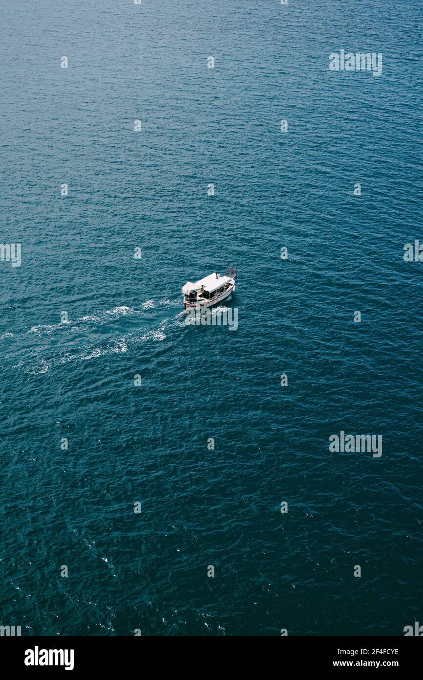Small tourist boat floats on water texture, aerial frame from helicopter Stock Photo Alamy
