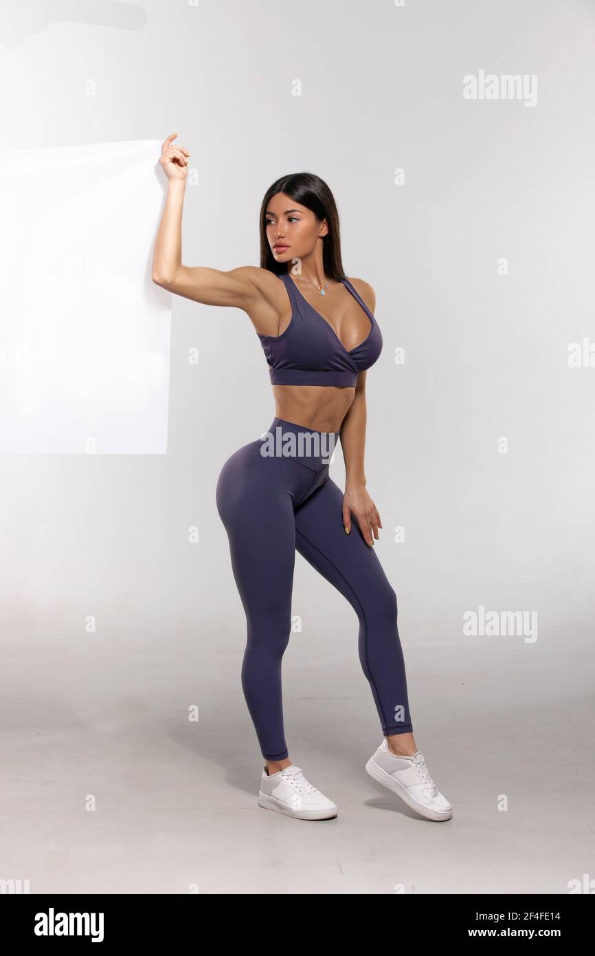 girl in purple leggings and top on a white background Stock Photo