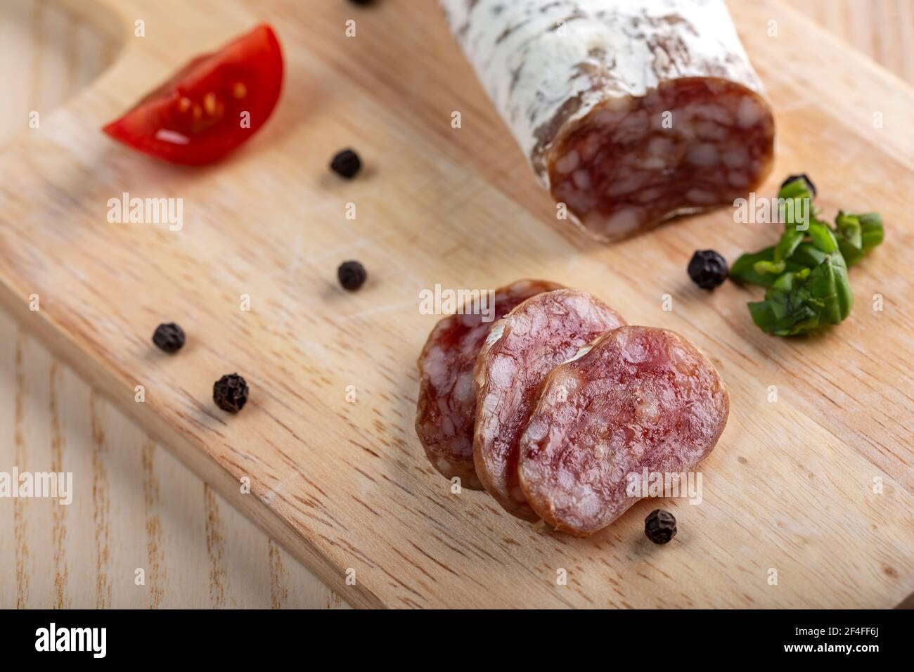 Homemade Italian salami on wooden cutting board - top view Stock Photo