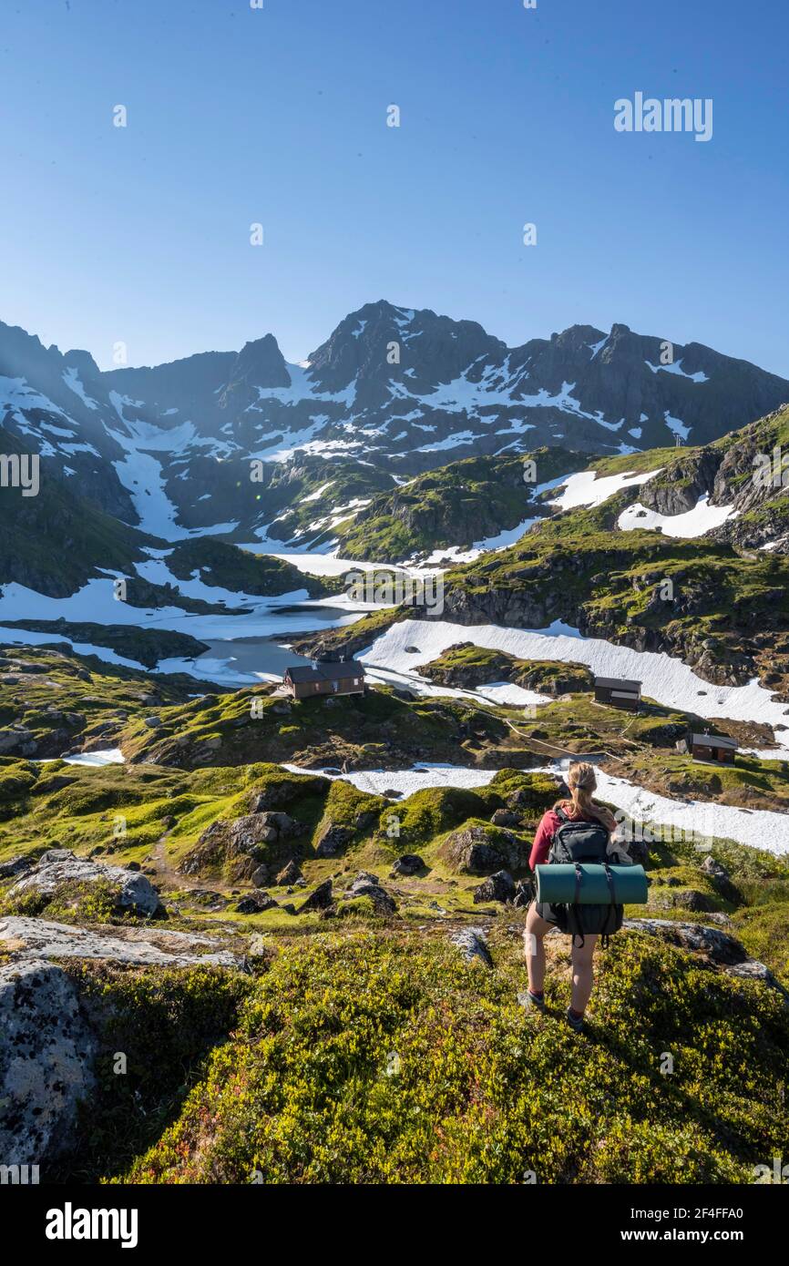Young woman hiking, mountains and snow, hiking to Trollfjord Hytta, at