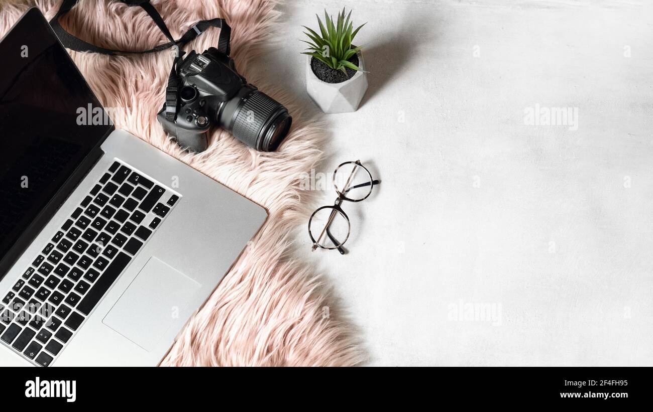 flat lay of workspace with laptop eyeglasses photo camera on white