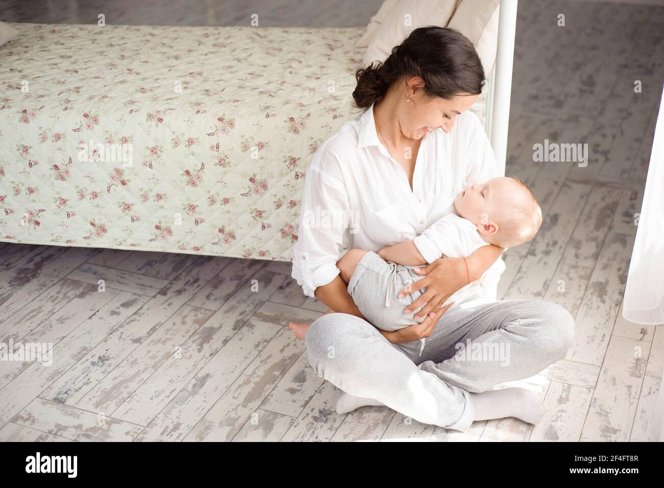 Baby sleeping on the mother's chest. Young mother cuddling baby Stock