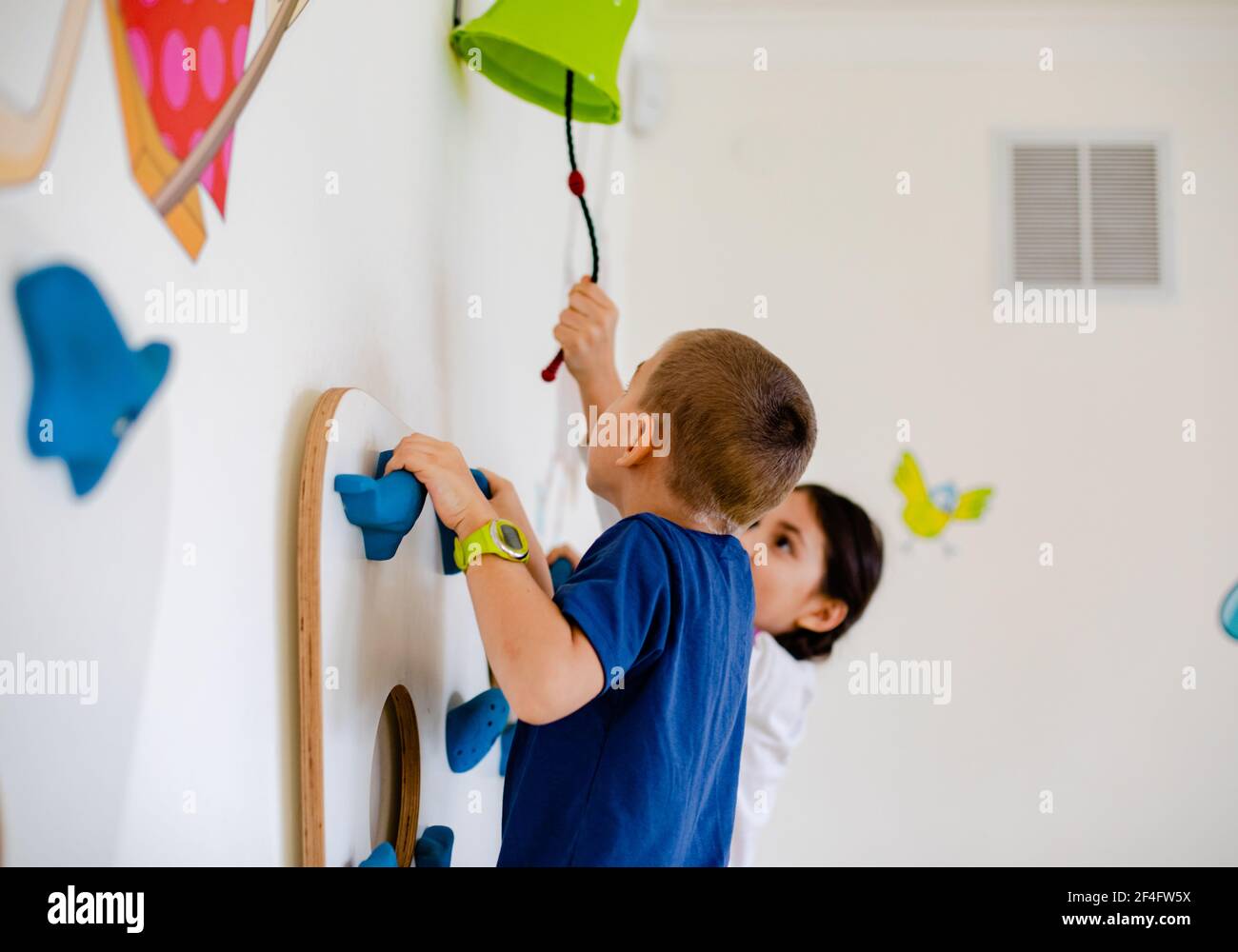 The kids play a dexterity game are climbing a wall Stock Photo