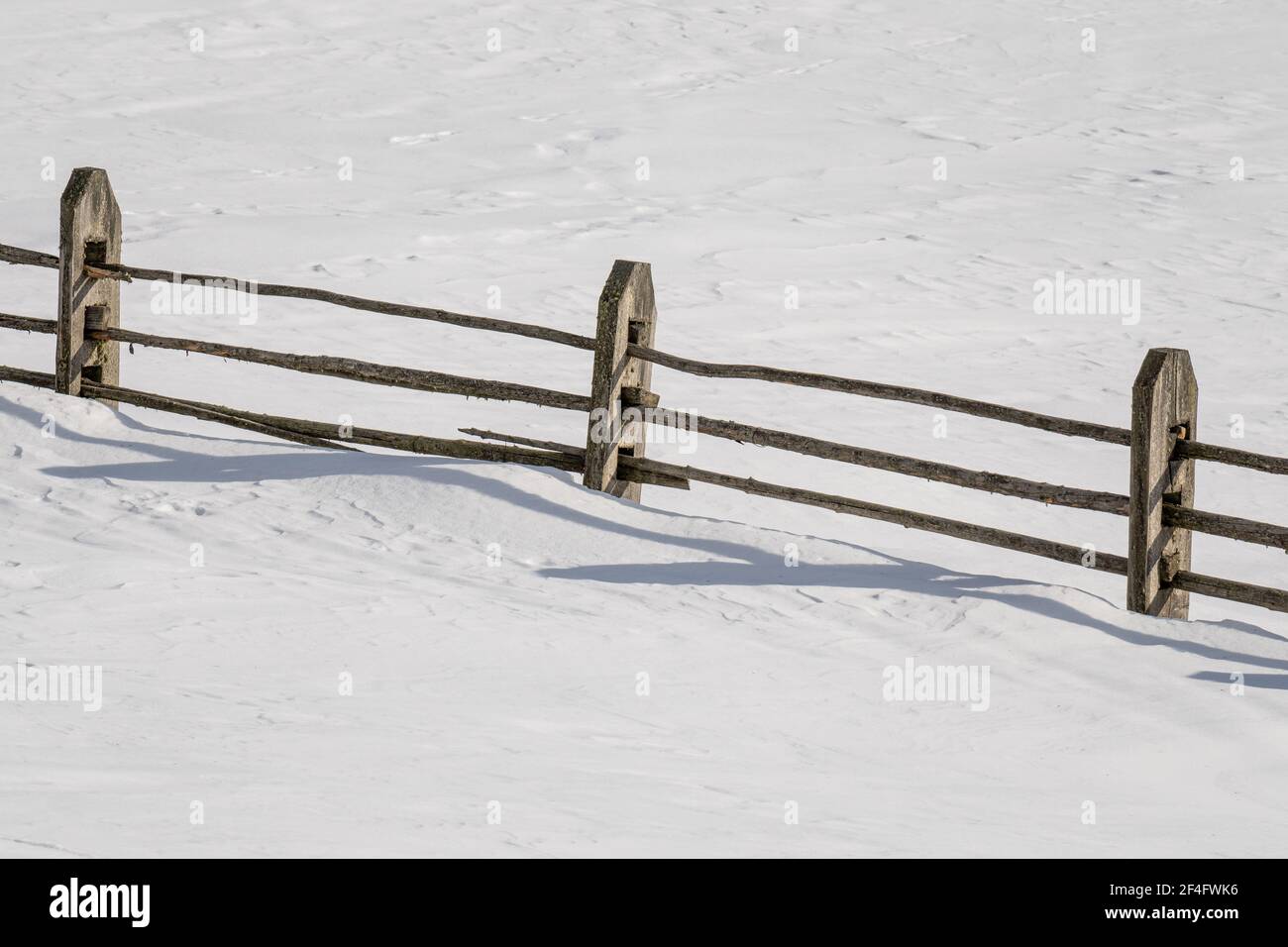 A closeup shot of a wooden fence on a snowy landscape Stock Photo - Alamy