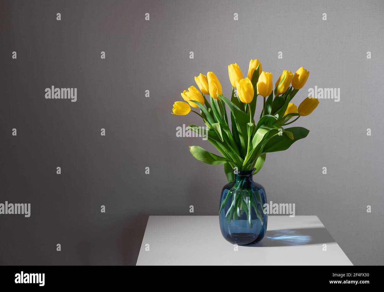 Still life with bunch of yellow tulips on white table Stock Photo - Alamy