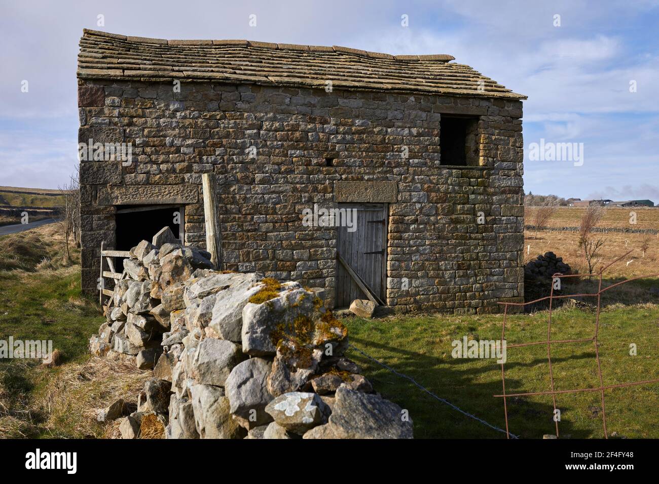 March sunlight highlights the moorland stone built field barn in Yorkshire Stock Photo