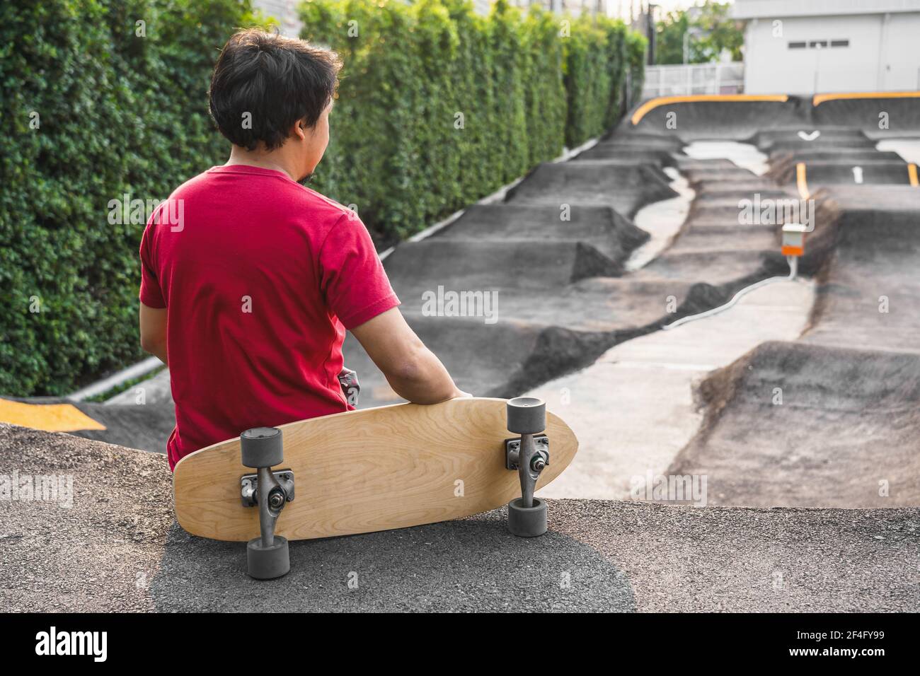 nadering Onbekwaamheid Christchurch Asian man sitting with surfskate or skate board in pumptrack skate Park  when sunrise time over photo blur of pumptrack curve, extream sport,  healthy a Stock Photo - Alamy