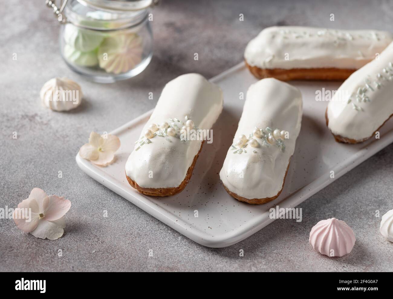 white glaze eclairs on white serving board Stock Photo