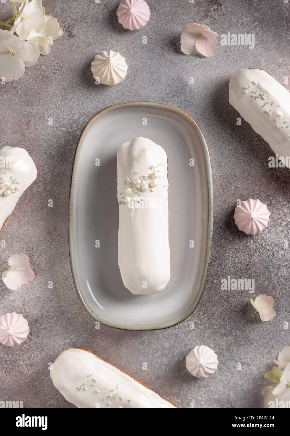 delicious white chocolate eclairs on flowers background Stock Photo