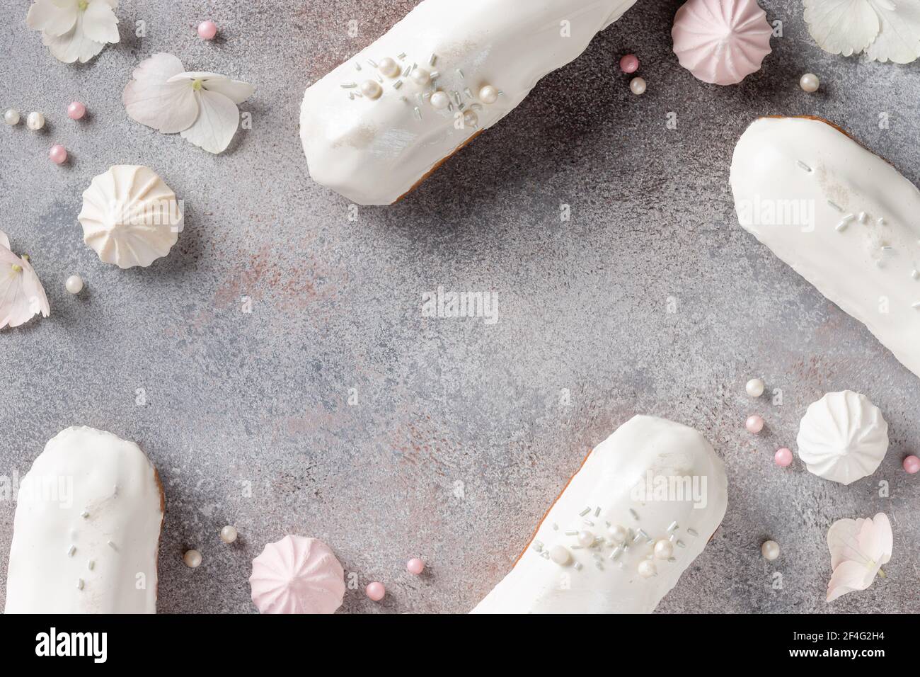 frame composition with white glaze eclairs, sweets, flowers Stock Photo