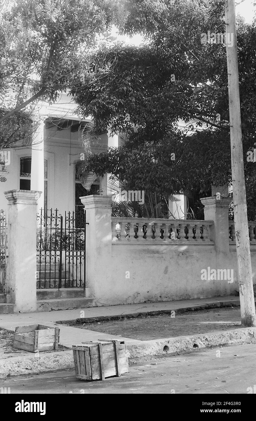 Collection Berm Discarded crates and a dirt berm, in front of a gated colonial building ...