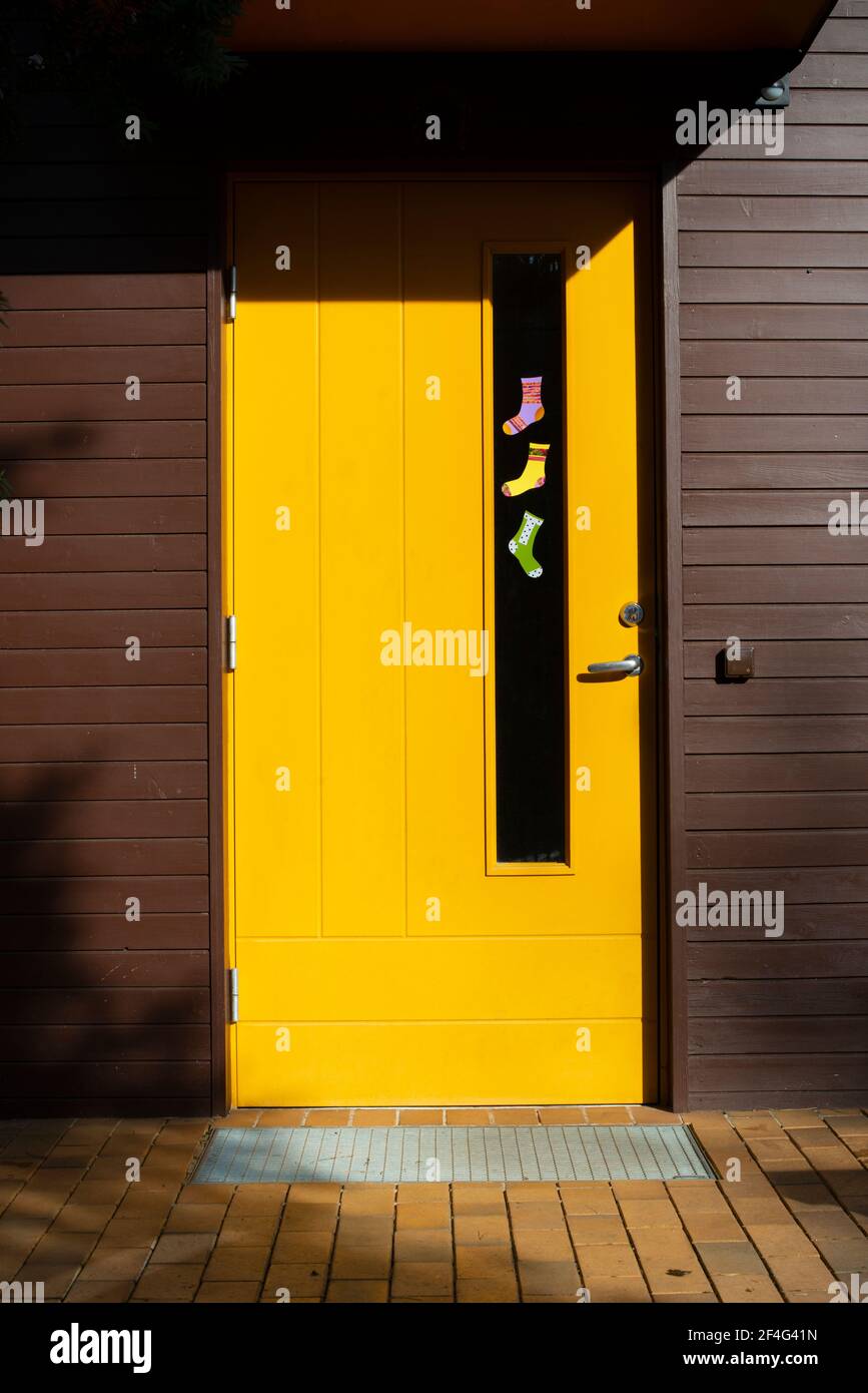 Paper socks of different colours hang on the door. World Down Syndrome Day. Sunny spring day. Stock Photo