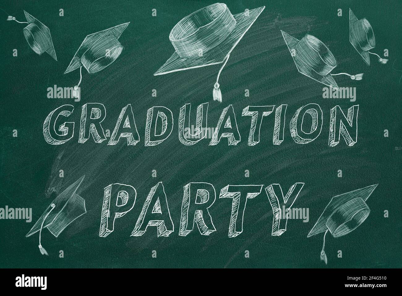 Hand drawing text 'Graduation party' and graduation caps  on green chalkboard. Stock Photo