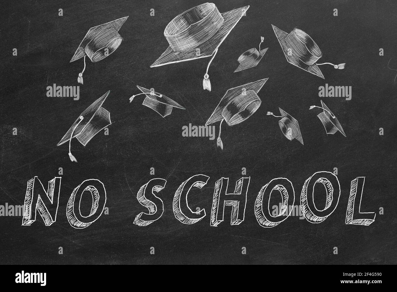 Hand drawing text 'NO  SCHOOL' and graduation caps on blackboard. Stock Photo
