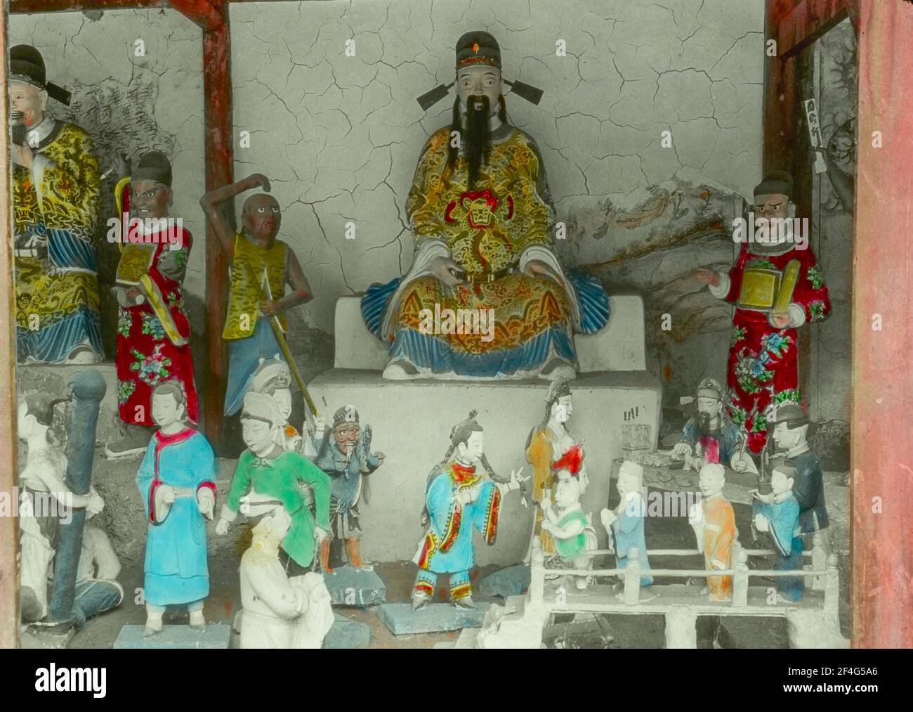 A colorful statuary vignette with a variety of human figures and a large central sculpture depicting a man, possibly an Emperor, wearing colorful Tang-era garments, Sichuan, China, 1917. From the Sidney D. Gamble photographs collection. () Stock Photo
