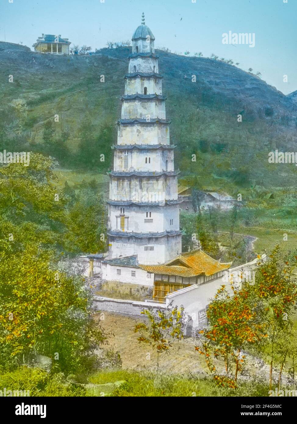 High-angle shot of a walled, ten-story pagoda, with a building on a hill in the background, Chongqing, China, 1917. From the Sidney D. Gamble photographs collection. () Stock Photo