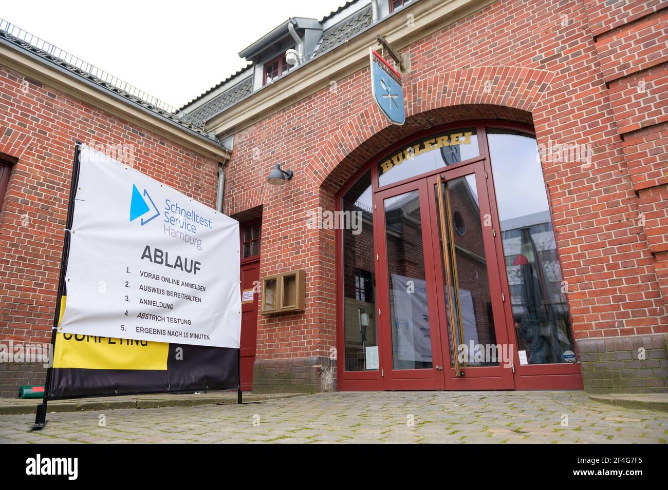 Hamburg, Germany. 18th Mar, 2021. Posters in front of the 'Bullerei' point out the test center. In the restaurant 'Bullerei' of the Hamburg restaurateur and TV chef Mälzer, Hamburgers can get tested for the corona virus free of charge. Credit: Jonas Walzberg/dpa/Alamy Live News Stock Photo