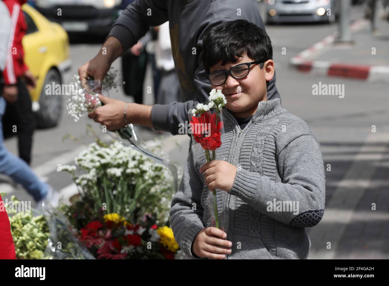 Nablus. 21st Mar, 2021. A Palestinian boy buys flowers on the occasion