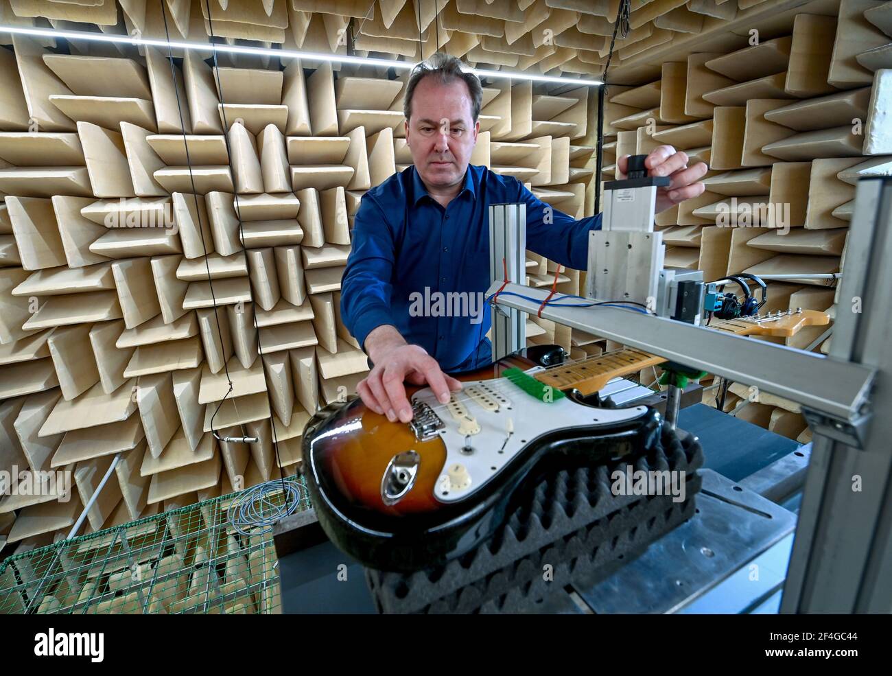 26 February 2021, Saxony, Zwota: Holger Schiema, Managing Director of the Institute for Musical Instrument Making in Zwota, sets up an electric guitar in the anechoic chamber. The institute conducts industry-related research for musical instrument making in Germany. The focus is on the use of various resonance woods for stringed and plucked instruments, manufacturing technologies and design details for the effect of acoustics. There is especially close cooperation with the instrument makers in the Vogtland Musikwinkel, with 120 companies and 1,300 employees one of the largest locations in the Stock Photo