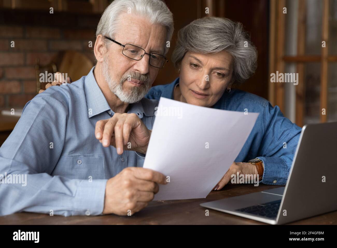 Old age married couple do paperwork engaged in reading document Stock Photo