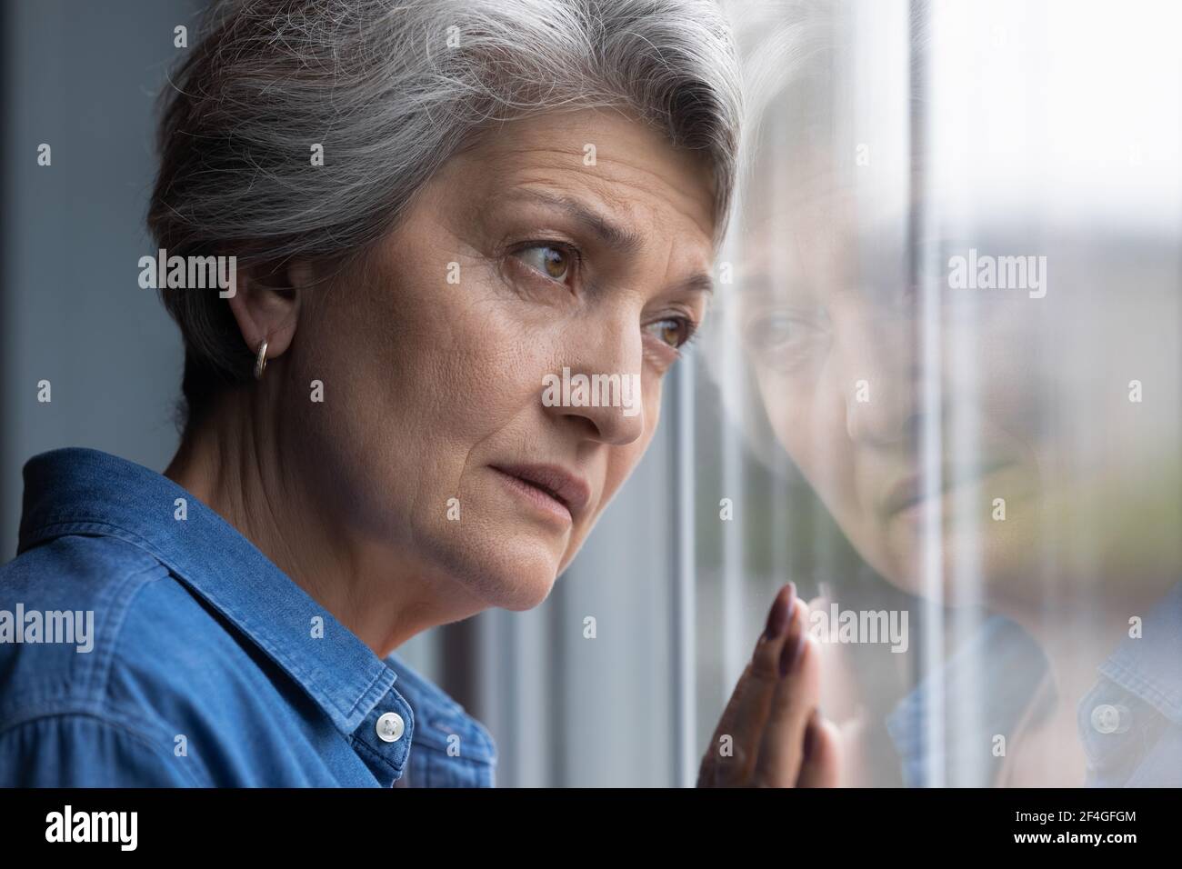 Depressed elderly hispanic lady widow mourning for gone husband Stock Photo