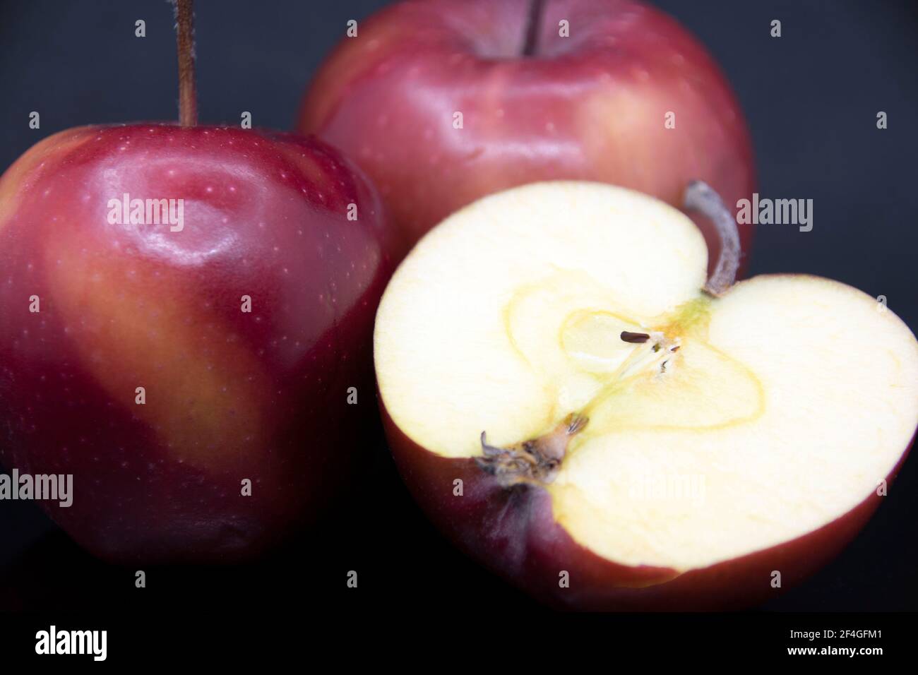 Red ripe apples on a black background.Cut red apple.Half an apple Stock ...