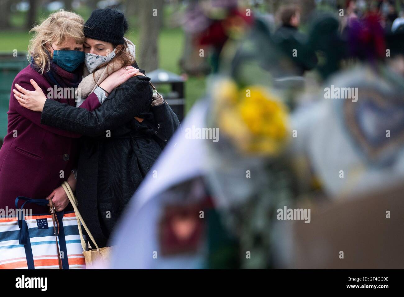 Two women hold each other as they look at floral tributes left at the bandstand in Clapham Common, London, for Sarah Everard. Pc Wayne Couzens, 48, appeared at the Old Bailey in London charged with the kidnap and murder of the 33-year-old. Picture date: Sunday March 21, 2021. Stock Photo