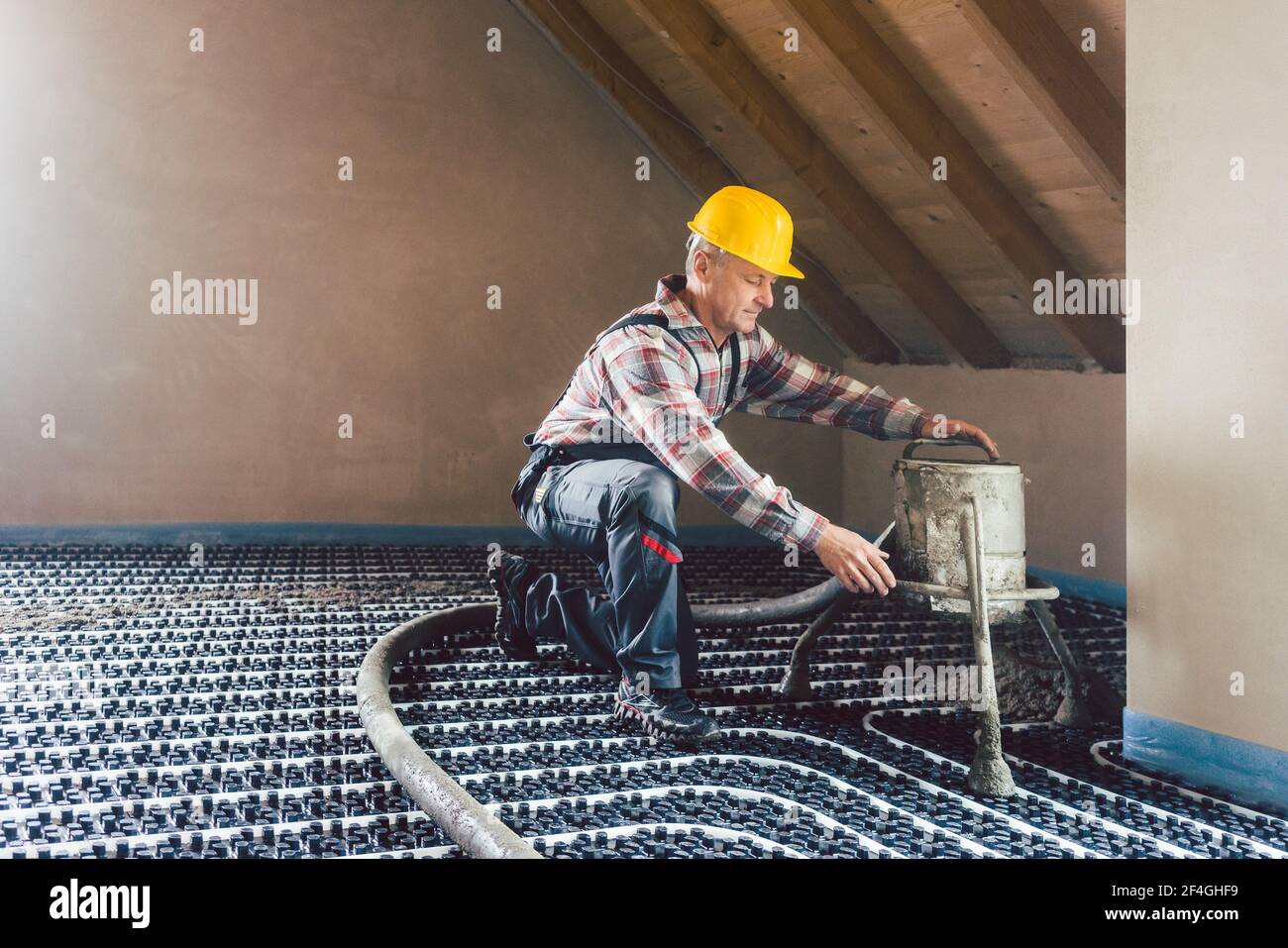 Worker on construction site installing pipes for underfloor heating Stock Photo