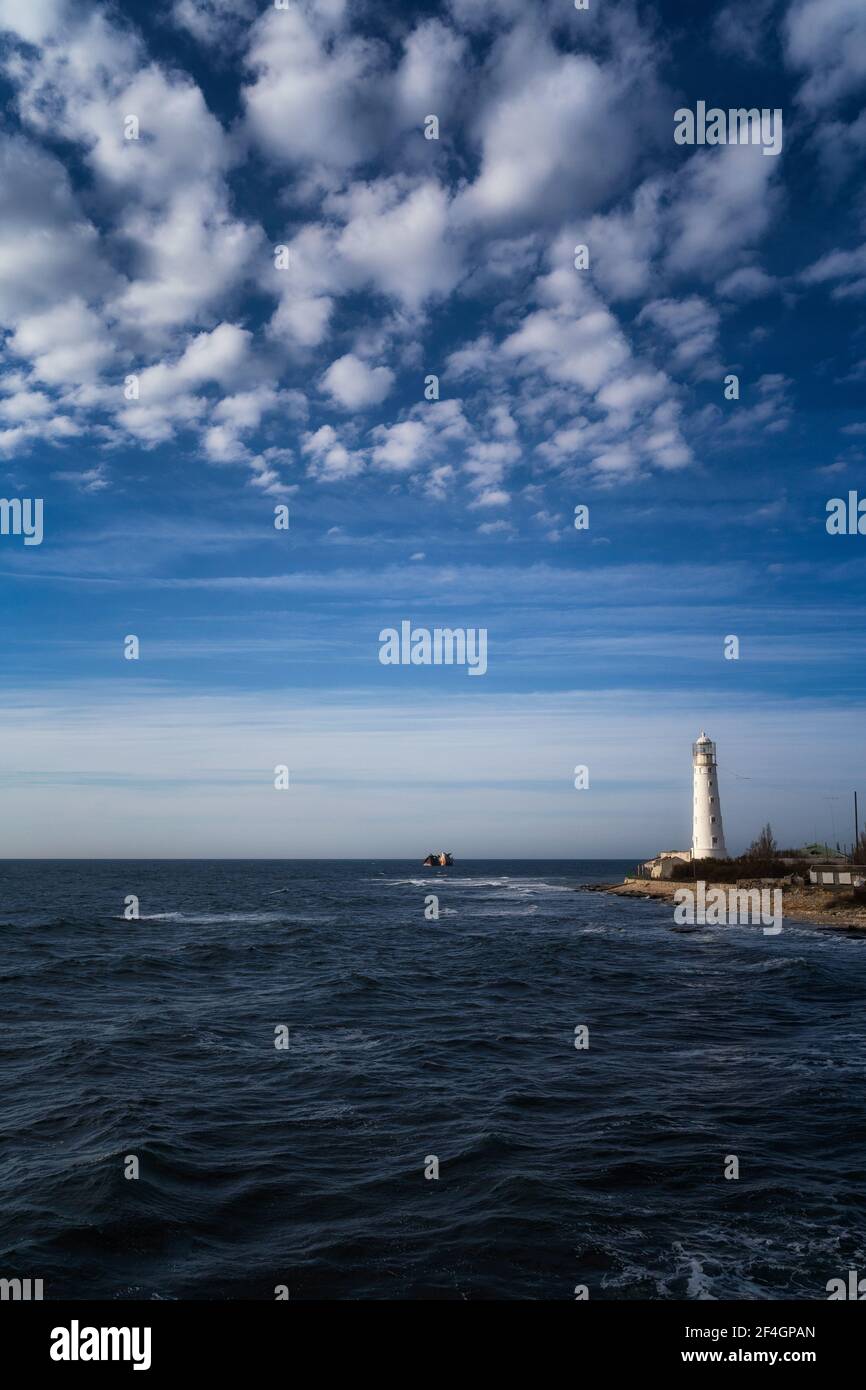 Lone beacon guards the ships. The lighthouse shows the way for boats ...