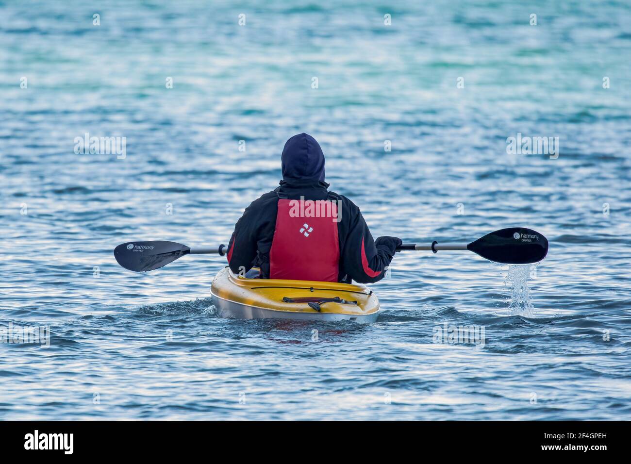 A middle aged man enjoying a late winter kayak adventure in the shipping canal connecting the bay of Green Bay with Lake Michigan near Sturgeon Bay Wi Stock Photo