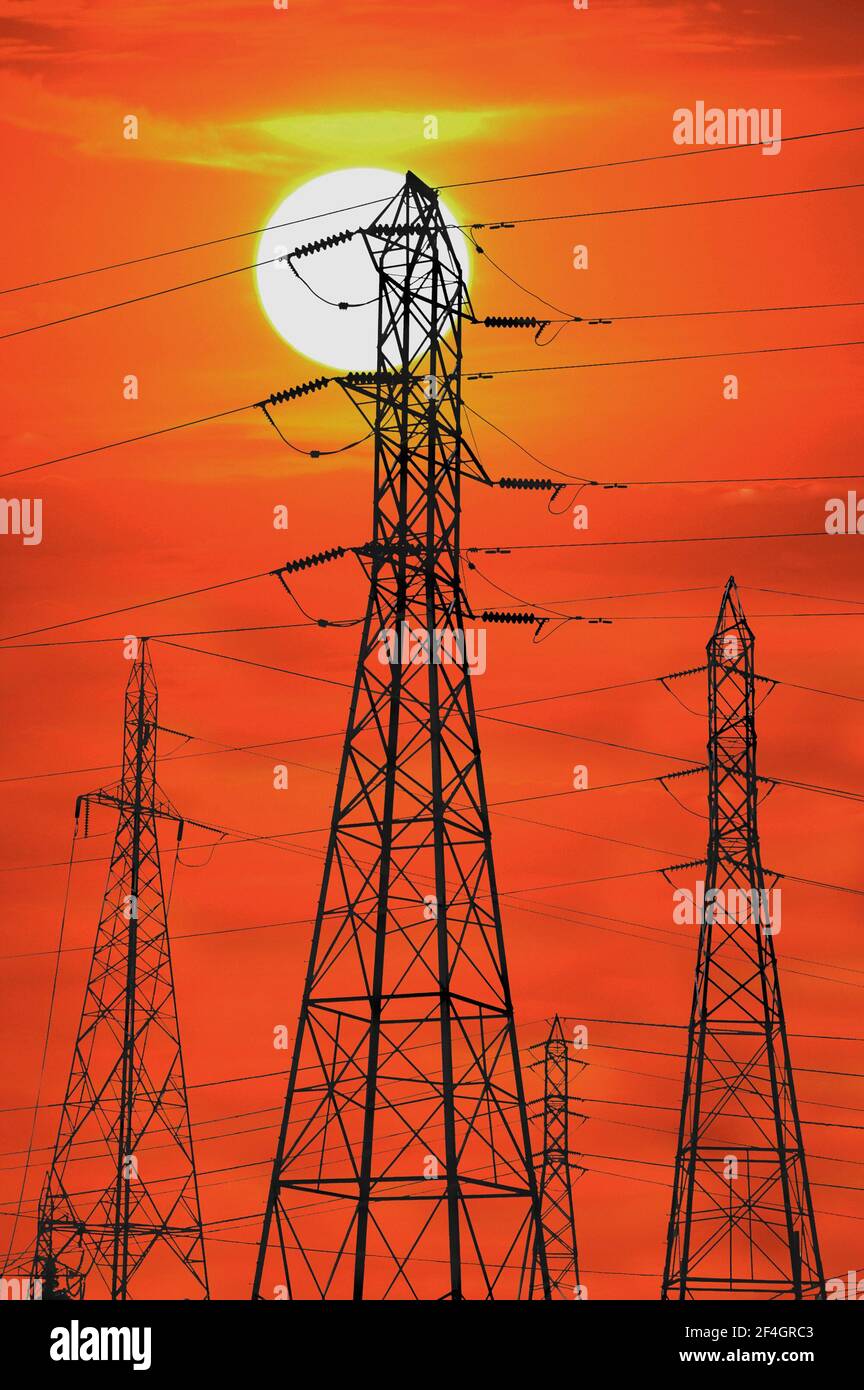 Sun sets over electrical power lines and towers Stock Photo