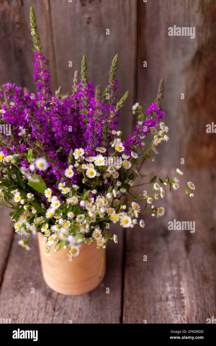 A bouquet of wild flowers. Summer wild flower. Wooden background and table. Place for text. Small Phalacrol and Veronica spicata. Copy space Stock Photo