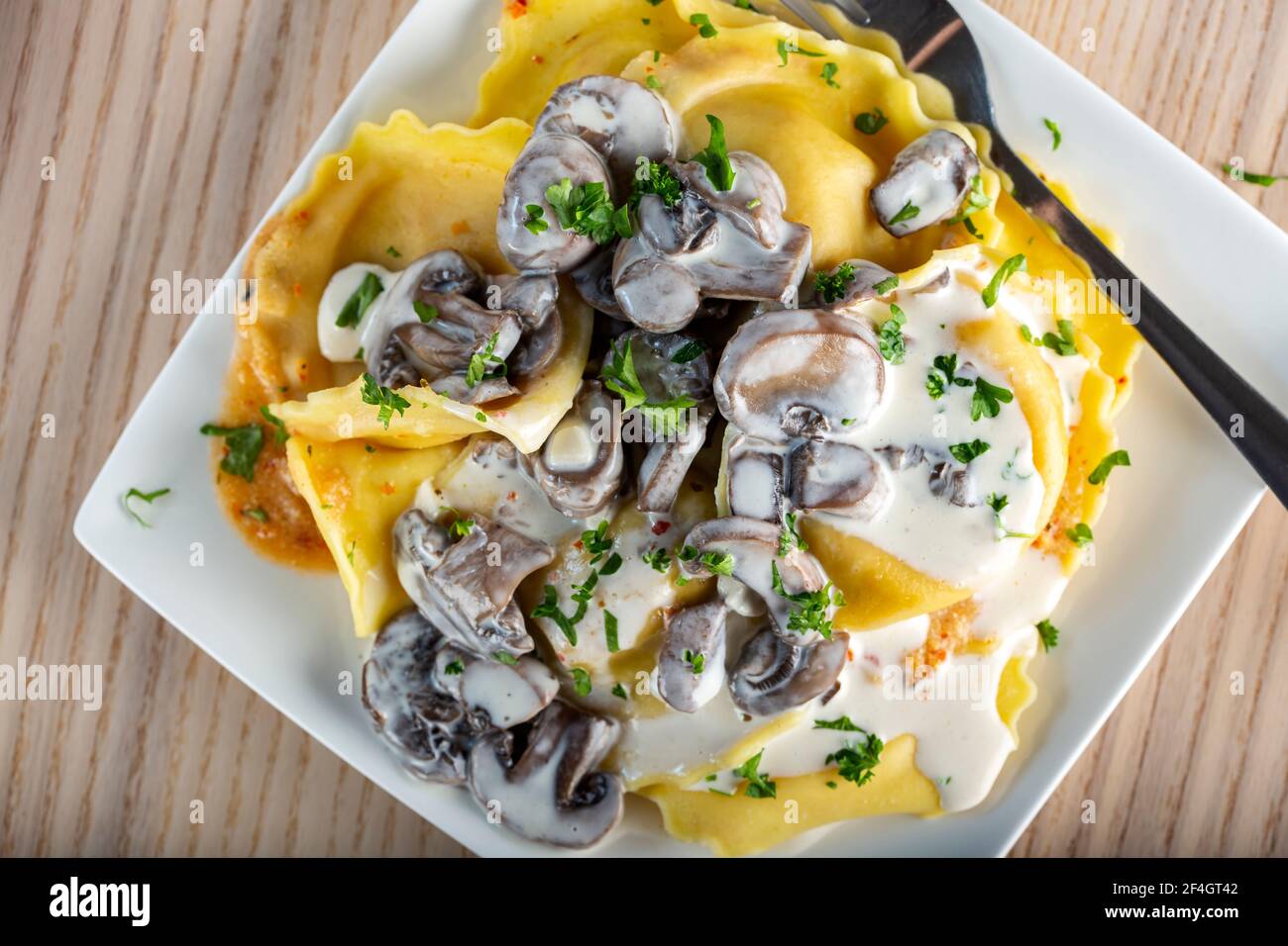 Ravioli filled with mozzarella cheese and red pepper with cream and  mushrooms sauce - top view Stock Photo - Alamy