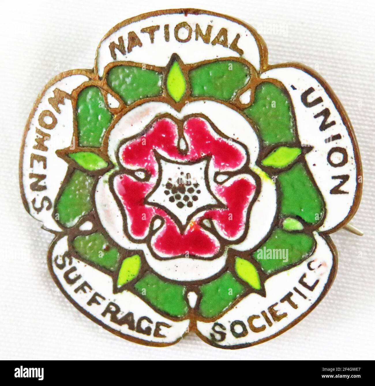 Red, green, and white, multi-lobed enamel pin or badge, with a stylized five-petalled red rose and the text 'National Union Women Suffrage Societies, ' manufactured by the National Union of Women Suffrage Societies (NUWSS), for the British market, 1905. Photography by Emilia van Beugen. () Stock Photo