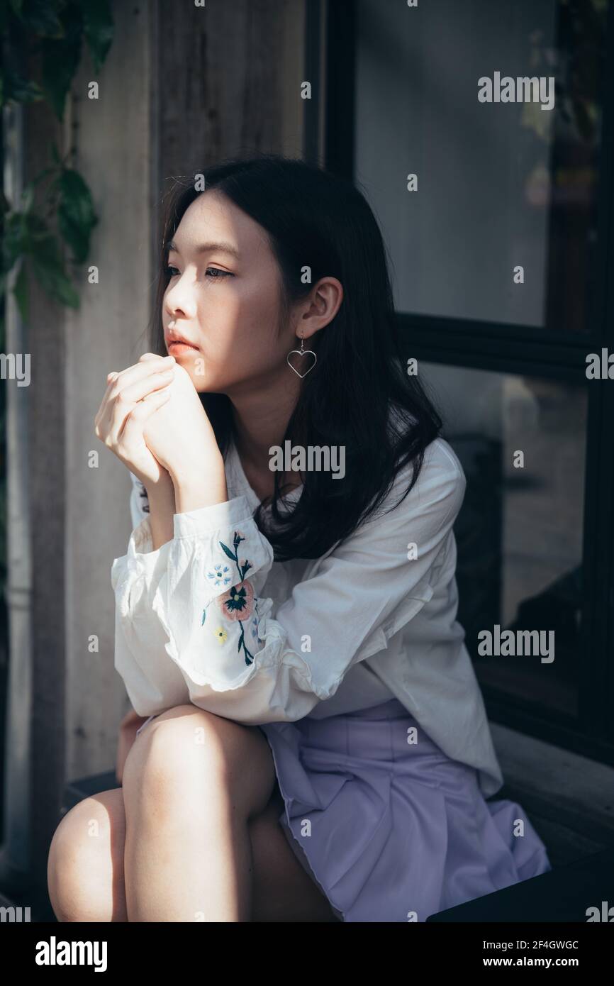 Portrait young woman thinking and looking modern style in outdoor urban ...