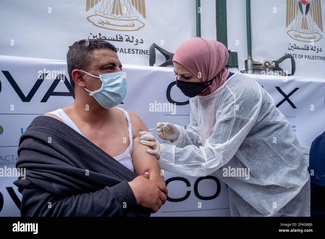 Ramallah. 21st Mar, 2021. A man receives the COVID-19 vaccine during a vaccination campaign in the West Bank city of Ramallah, on March 21, 2021. Palestine on Sunday launched a mass vaccination rollout campaign against coronavirus in a bid to combat the fast-spreading virus across the West Bank and the Gaza Strip. Credit: Luay Sababa/Xinhua/Alamy Live News Stock Photo