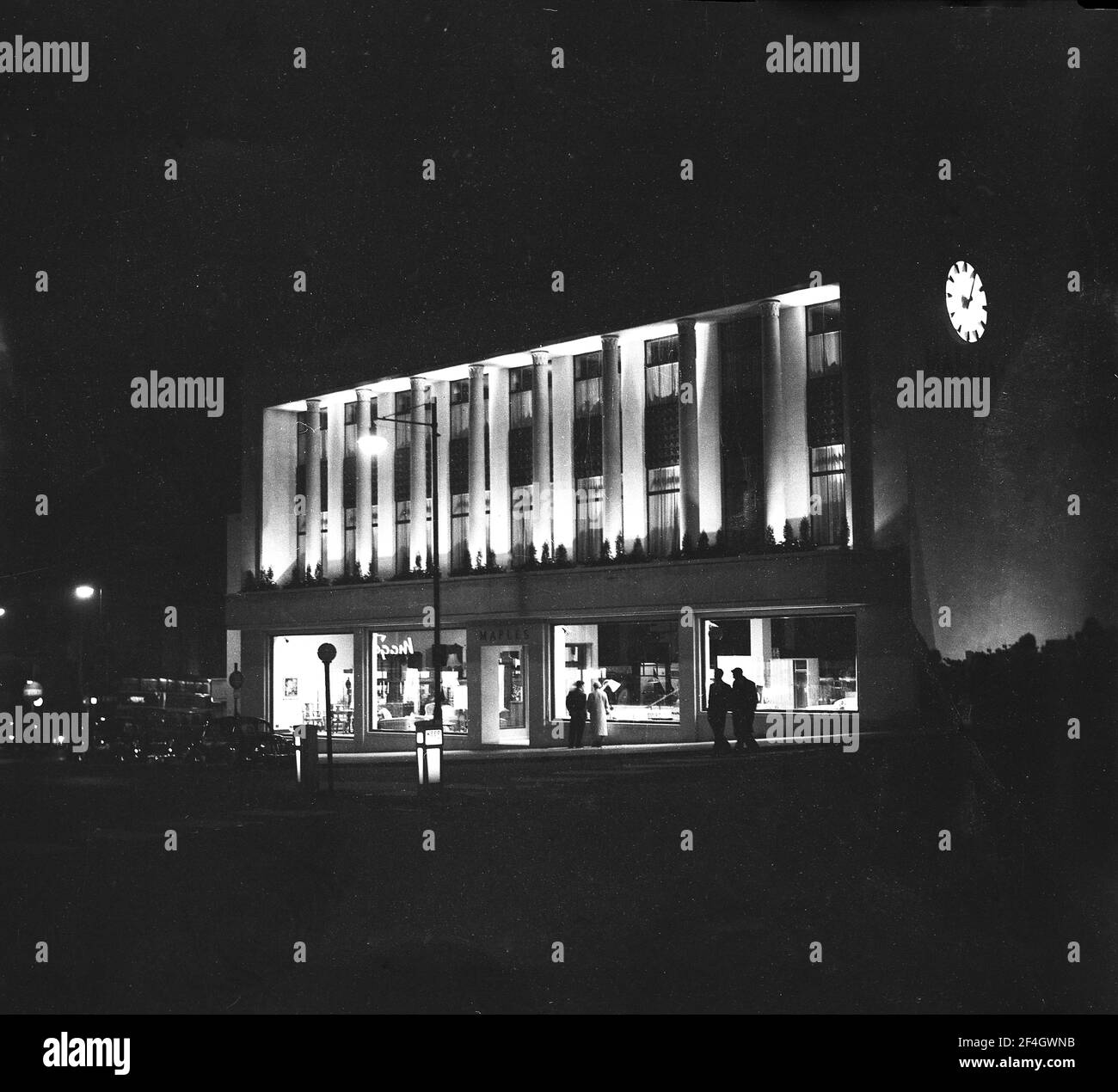 1956, historical, eveningtme and the exterior of the Maples furniture store, The Triangle, Clifton, Bristol, England, UK lit up, newly built from the bomb damaged city of WW2. Stock Photo