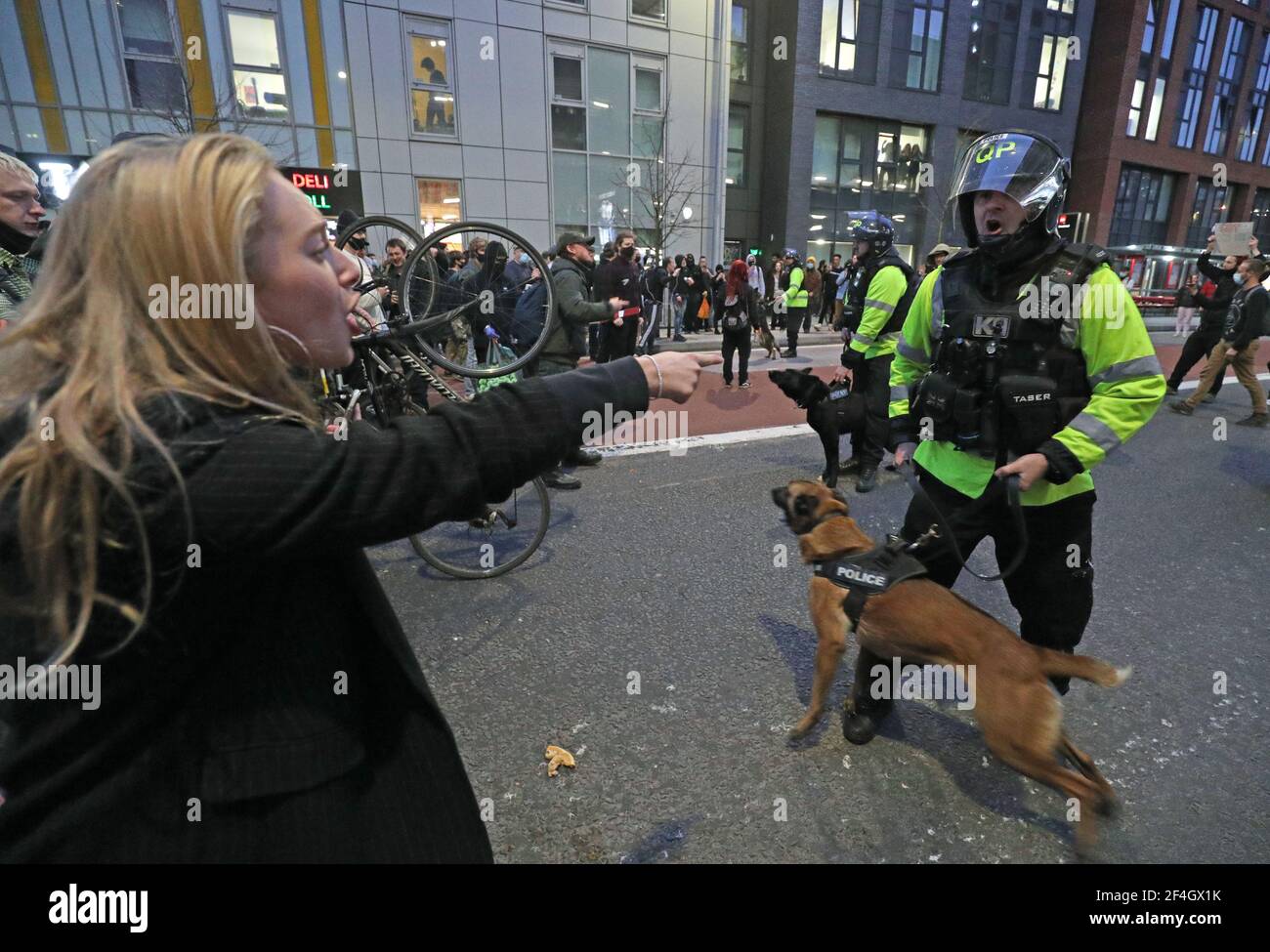 A police officer with a police dog faces protesters outside Bridewell Police Station as they take part in a 'Kill the Bill' protest in Bristol, demonstrating against the Government's controversial Police and Crime Bill. Picture date: Sunday March 21, 2021. Stock Photo